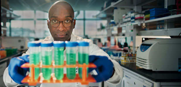 Researcher in a lab holding beakers